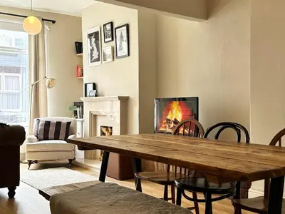 a living room with a wooden table and a fireplace at 1 min to Everton FC Free Parking, Farmhouse Chic in Liverpool