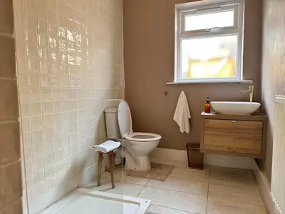 a bathroom with a toilet and a sink and a window at 1 min to Everton FC Free Parking, Farmhouse Chic in Liverpool