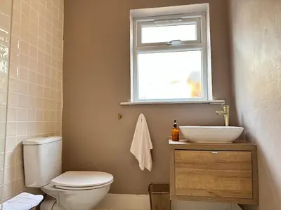 a bathroom with a toilet and a sink and a window at 1 min to Everton FC Free Parking, Farmhouse Chic in Liverpool