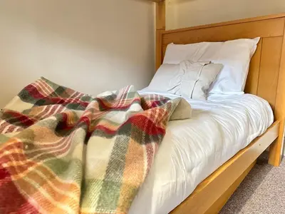 a bed with a wooden frame with a blanket on it at 1 min to Everton FC Free Parking, Farmhouse Chic in Liverpool
