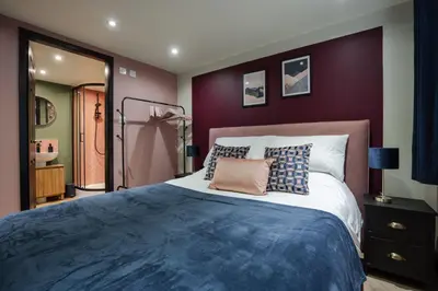 a bedroom with a large bed with purple walls at The Lodge in Woodplumpton