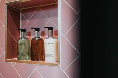 two bottles ofodorizers sit on a shelf in a bathroom at The Lodge in Woodplumpton