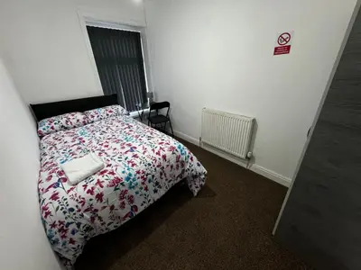 a bedroom with a bed with a floral comforter at Double bed BW2 Accrington Burnley in Accrington