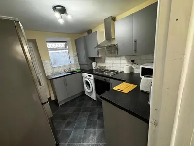 a kitchen with gray cabinets and a black counter top at Double bed BW2 Accrington Burnley in Accrington