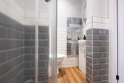 a bathroom with a toilet and a glass shower at Cosy Home 2 Bedroom House Birkdale in Southport