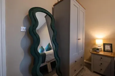 a bedroom with a large mirror on the wall at Cosy Home 2 Bedroom House Birkdale in Southport