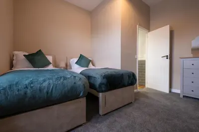 a bedroom with two twin beds and a closet at Cosy Home 2 Bedroom House Birkdale in Southport