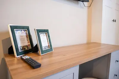 a counter with two pictures and a remote control on it at Cosy Home 2 Bedroom House Birkdale in Southport