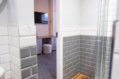 a bathroom with a shower with white tiles at Cosy Home 2 Bedroom House Birkdale in Southport