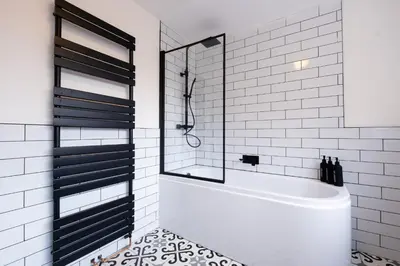 a white bathroom with a tub and a glass shower at Cosy Home 2 Bedroom House Birkdale in Southport