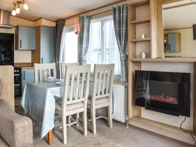 a dining room with a table and a fireplace at Ocean View in Lancaster