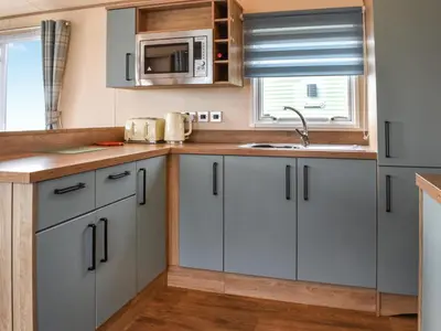 a kitchen with white cabinets and a sink at Ocean View in Lancaster