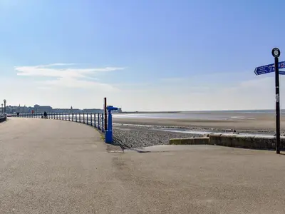 a beach with a blue fence next to the ocean at Promenade - Uk48690 in Lancaster