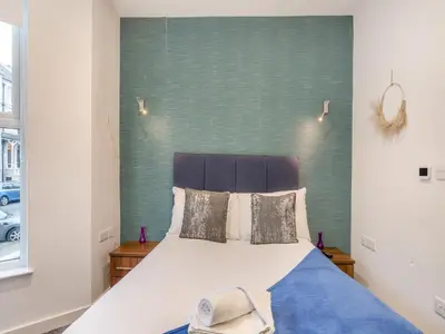 a bedroom with a bed with a green headboard at Promenade - Uk48690 in Lancaster