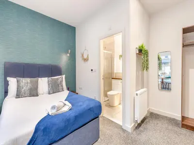 a bedroom with a bed with a blue accent wall at Promenade - Uk48690 in Lancaster