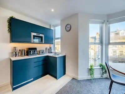 a kitchen with blue cabinets and a microwave at Pier View - Uk48691 in Lancaster