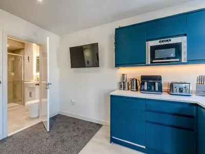 a kitchen with blue cabinets and a microwave at Pier View - Uk48691 in Lancaster