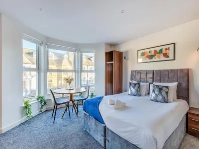 a bedroom with a large bed and a table at Pier View - Uk48691 in Lancaster