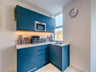 a kitchen with blue cabinets and a clock on the wall at Sand Dune - Uk48699 in Lancaster