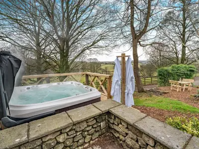 a hot tub in a stone wall in a yard at The B Hive At Buckstone House in Carnforth