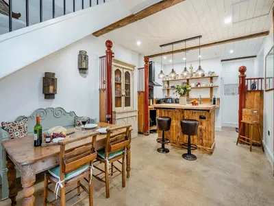 a kitchen and dining room with a wooden table and chairs at The B Hive At Buckstone House in Carnforth