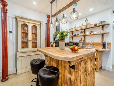 a kitchen with a wooden island with a bowl of fruit at The B Hive At Buckstone House in Carnforth