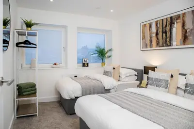 two beds in a room with two windows at Luxury Apartment - Sleeps 5 - Rose Platinum Properties in Liverpool