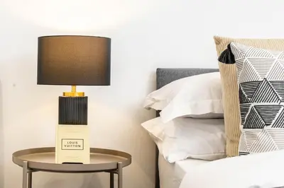 a lamp on a table next to a bed at Luxury Apartment - Sleeps 5 - Rose Platinum Properties in Liverpool