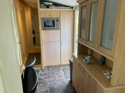 a small kitchen with a chair and a microwave at Willow summer house in Heysham