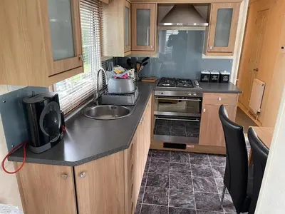 a kitchen with a sink and a stove at Willow summer house in Heysham