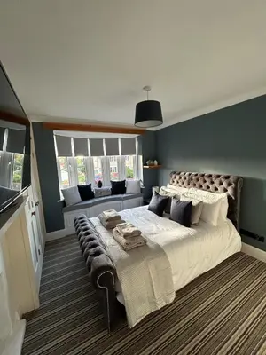a bedroom with a large bed with a bench on it at The Willows in Whalley