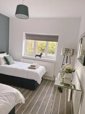 a bedroom with two beds and a window at The Willows in Whalley