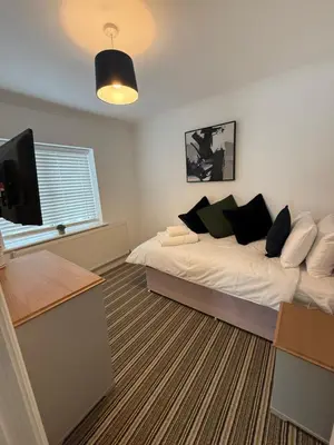 a bedroom with a bed and a flat screen tv at The Willows in Whalley