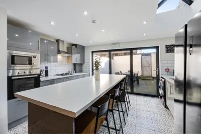 a kitchen with a large island with chairs in it at Thirlmere House - Air Host & Stay - 5 Bedrooms in Liverpool