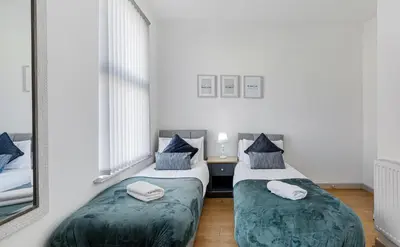 two twin beds in a room with a mirror at Thirlmere House - Air Host & Stay - 5 Bedrooms in Liverpool