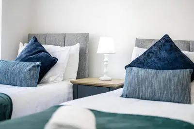 two beds with blue and white pillows in a room at Thirlmere House - Air Host & Stay - 5 Bedrooms in Liverpool