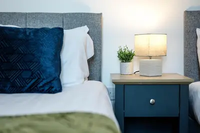a bedroom with a bed and a nightstand with a lamp at Thirlmere House - Air Host & Stay - 5 Bedrooms in Liverpool