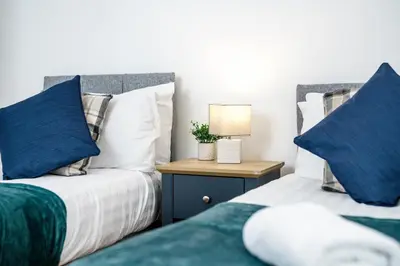 two beds sitting next to each other in a bedroom at Thirlmere House - Air Host & Stay - 5 Bedrooms in Liverpool