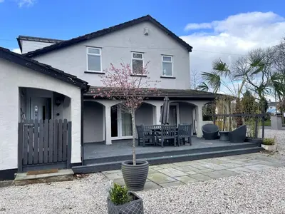 a house with a porch with a table and chairs at The Old Nursery in Blackburn