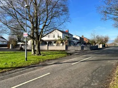 an empty street in a residential neighborhood with houses at The Old Nursery in Blackburn