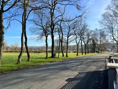 an empty road with trees on the side of the road at The Old Nursery in Blackburn