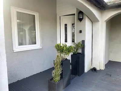 a front door of a house with two potted plants at The Old Nursery in Blackburn