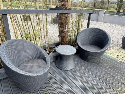 three wicker seats and a tree on a deck at The Old Nursery in Blackburn