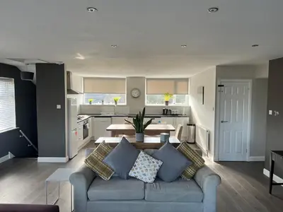 a living room with a couch and a kitchen at The Old Nursery in Blackburn