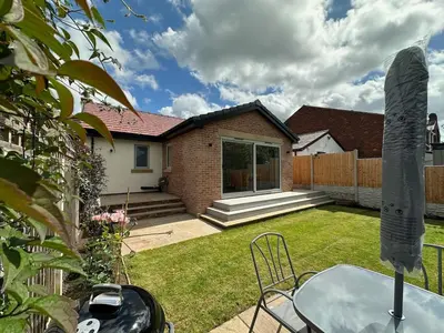 a house with a table and chairs in a yard at Poppy Cottage, Mawdesley Village in Mawdesley