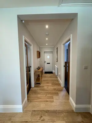 a hallway with white walls and wooden floors at Poppy Cottage, Mawdesley Village in Mawdesley