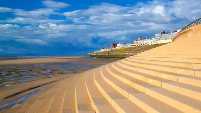 a staircase on the beach next to the ocean at The Golden Sands in Blackpool