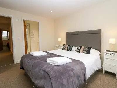 a bedroom with a large bed with two towels on it at 4 Teal House in Carnforth