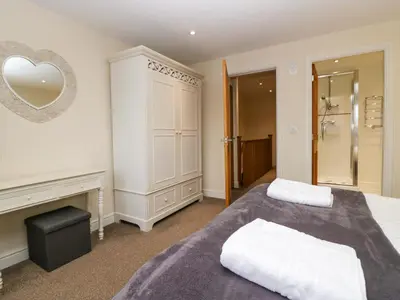 a bedroom with a bed and a mirror on the wall at 4 Teal House in Carnforth