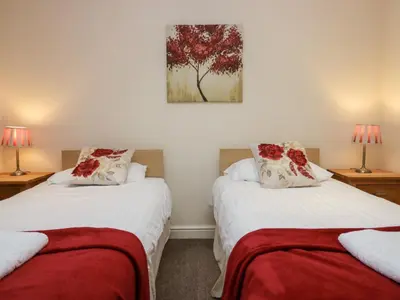 two beds in a room with two lamps at 4 Teal House in Carnforth